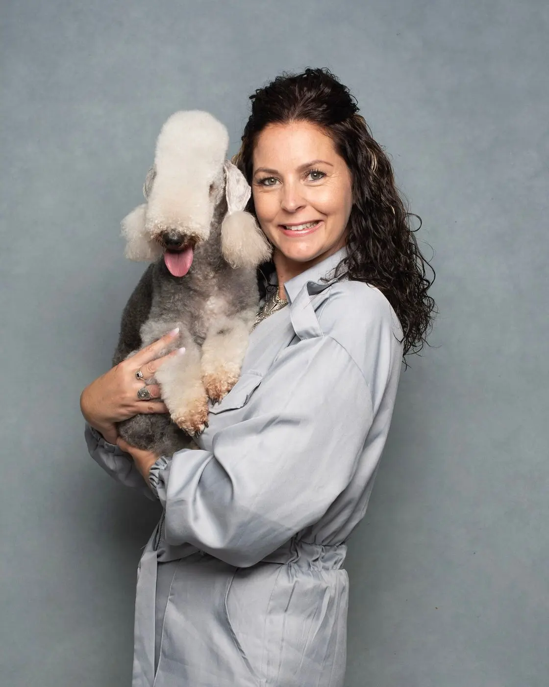 Kelly Davis, founder of KD Grooming Studio, holding a white dog